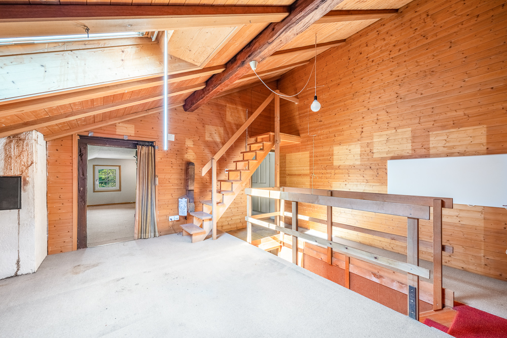 Heller Dachgeschossraum mit Holzverkleidung und Treppe