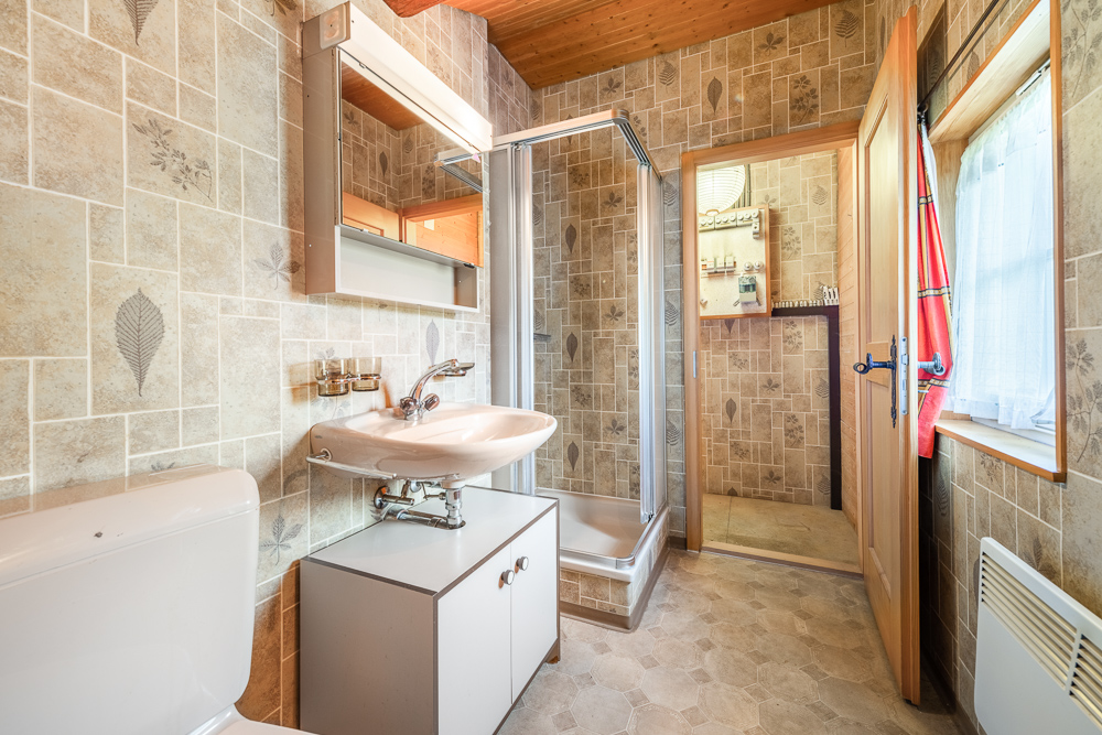 Kleines Badezimmer mit Dusche und Waschtisch