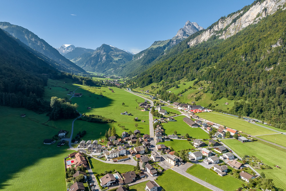 Luftaufnahme eines alpinen Tals mit Dorf