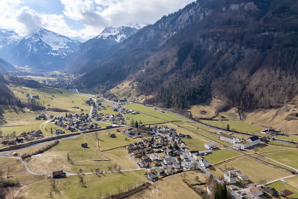 Luftaufnahme eines Bergtals mit Ortschaft
