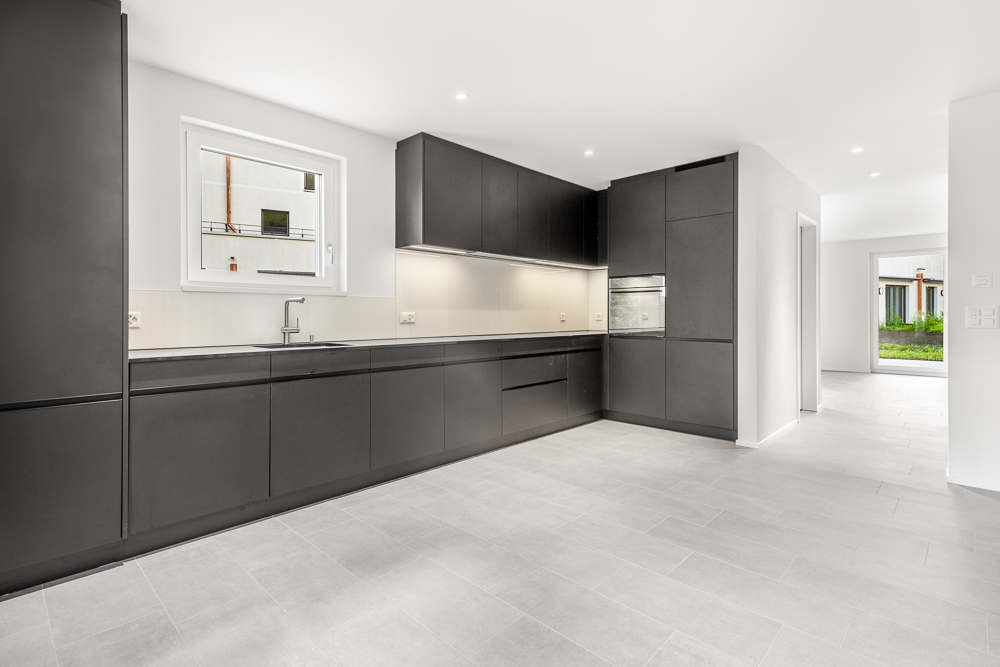Moderne, dunkle Einbauküche in offenem Grundriss