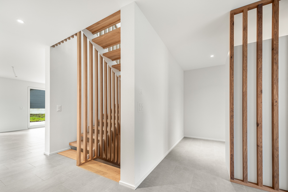 Moderner Flur mit Holzlamellen und offener Treppe