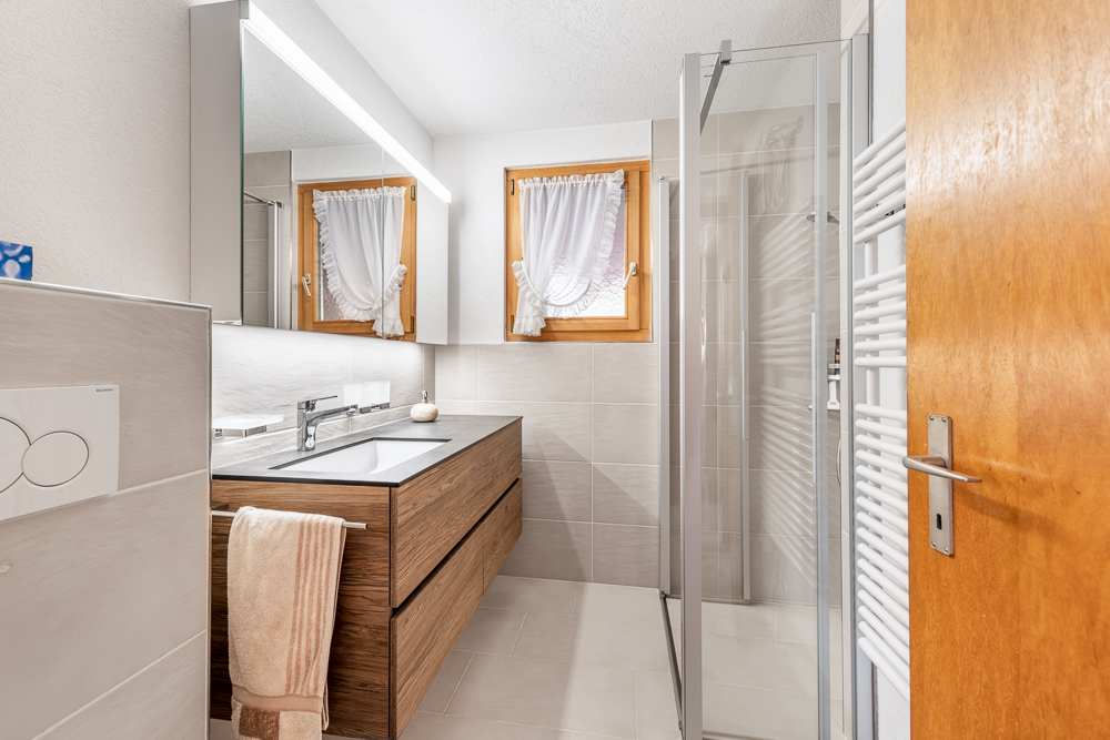 Modernes Badezimmer mit Holz- und Glasakzenten