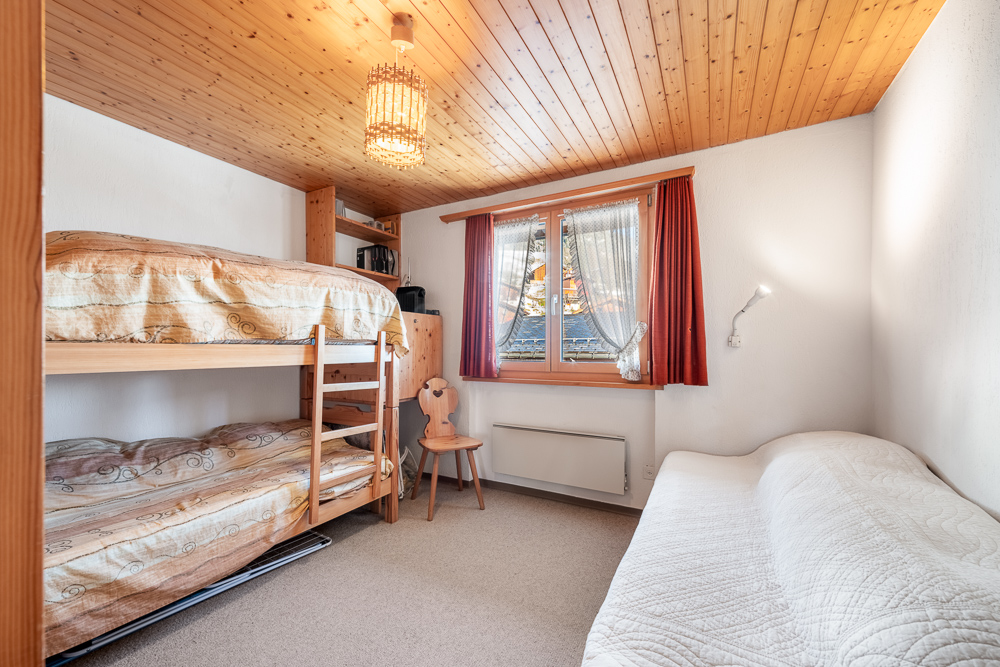 Schlafzimmer mit Etagenbett und Holzdecke