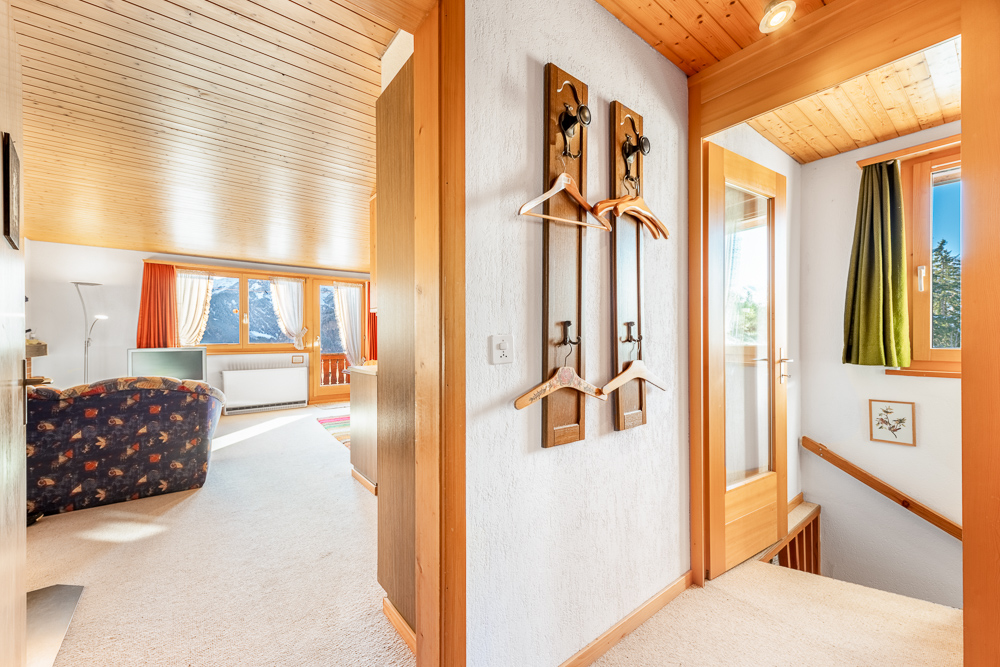 Heller Flur mit Treppe und Blick in ein Wohnzimmer