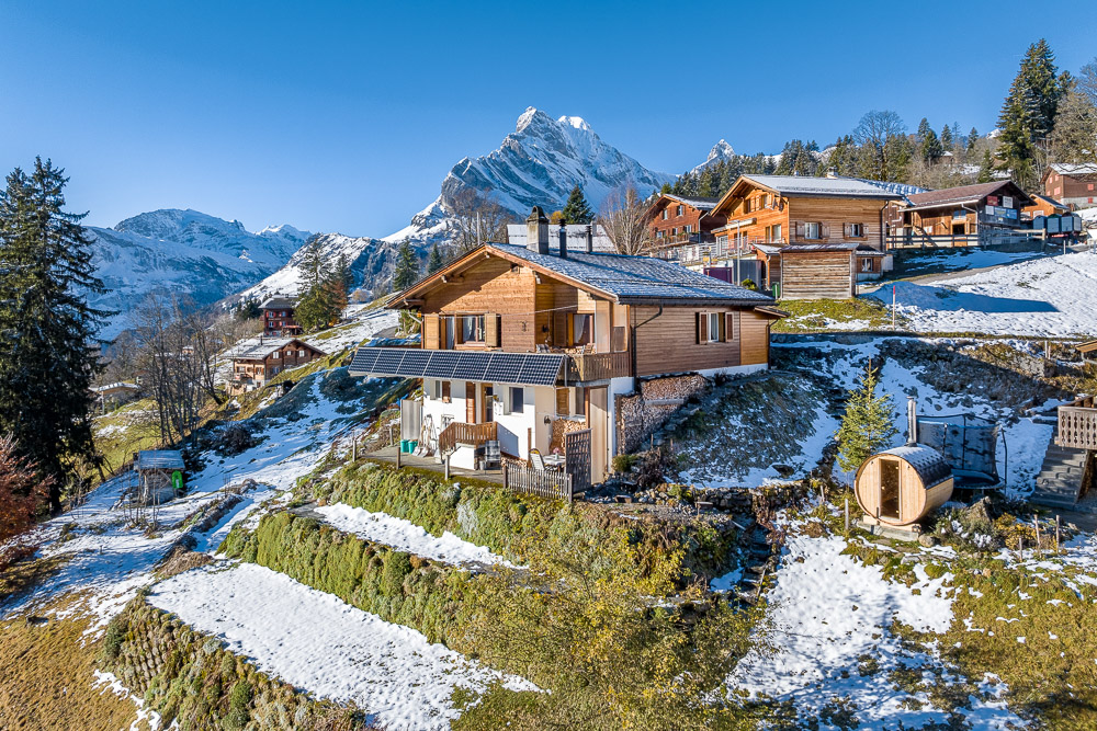 Alpines Holzhaus im Schnee mit Bergblick