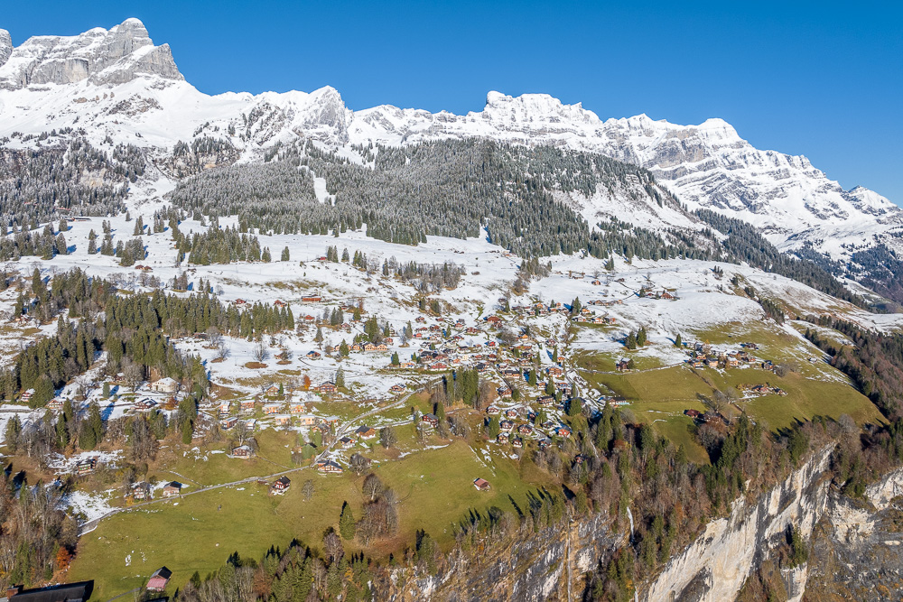 Alpine Landschaft mit verschneiten Bergen und Talort