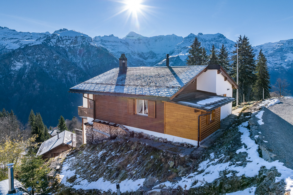 Berghaus mit Schneelandschaft und Alpenpanorama