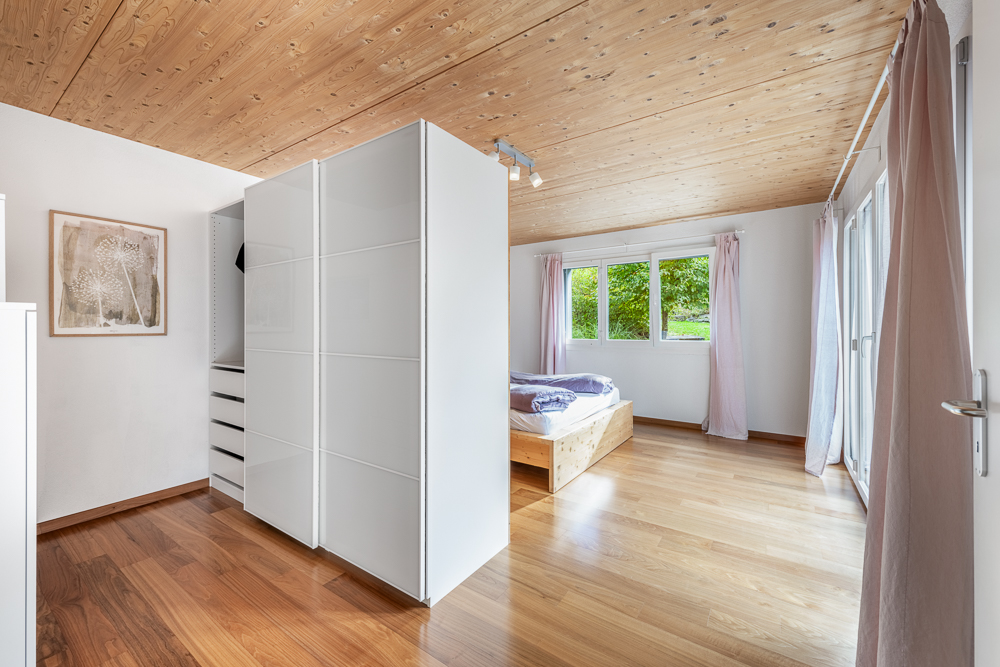 Helles Schlafzimmer mit Holzdecke und Einbauschrank