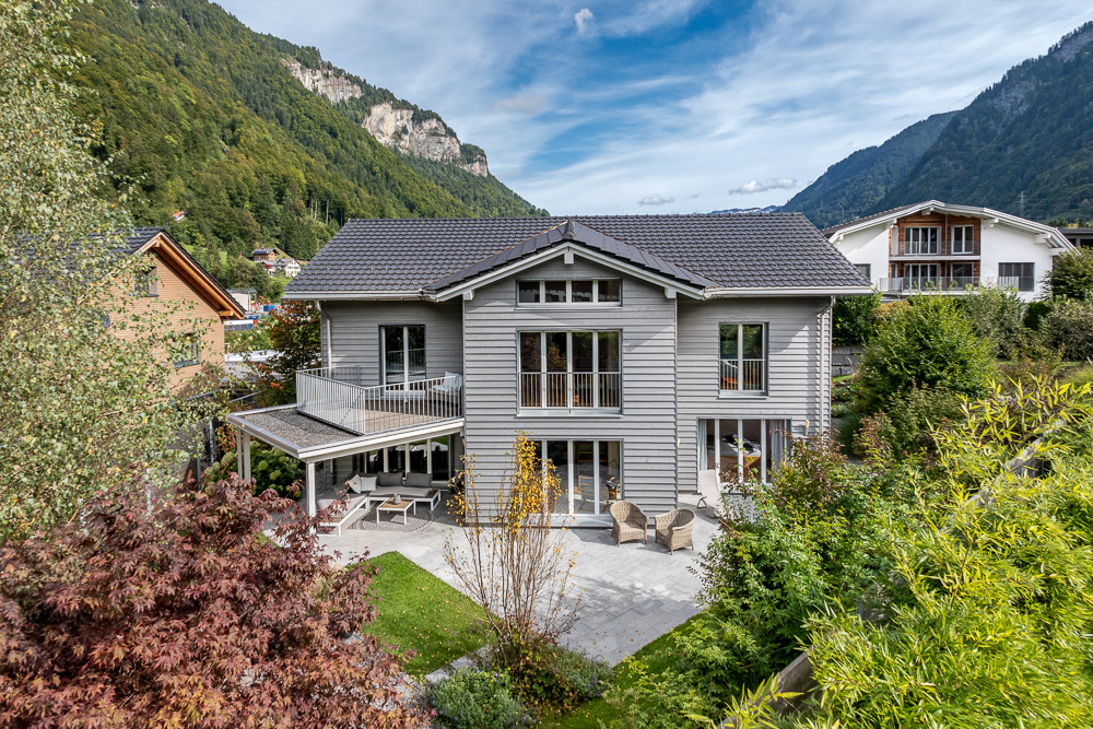 Modernes Einfamilienhaus mit Garten und Bergkulisse