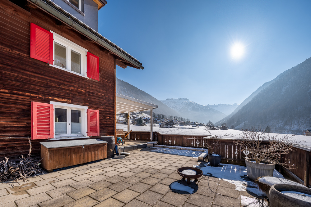 Alpenterrasse mit Chalet und Bergblick