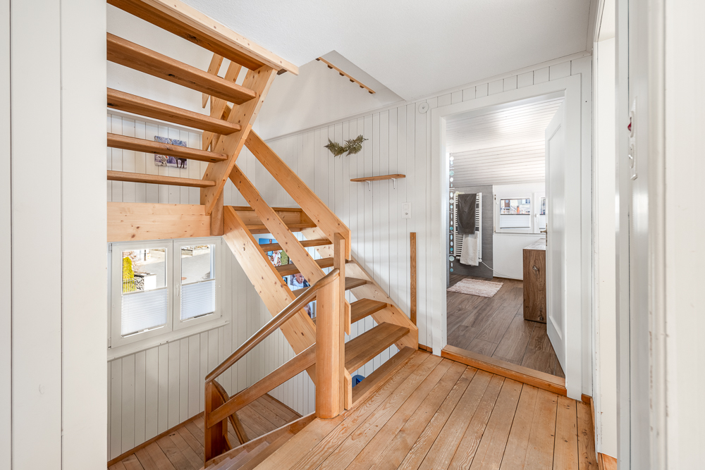 Treppenhaus mit Blick in ein helles Obergeschoss-Bad