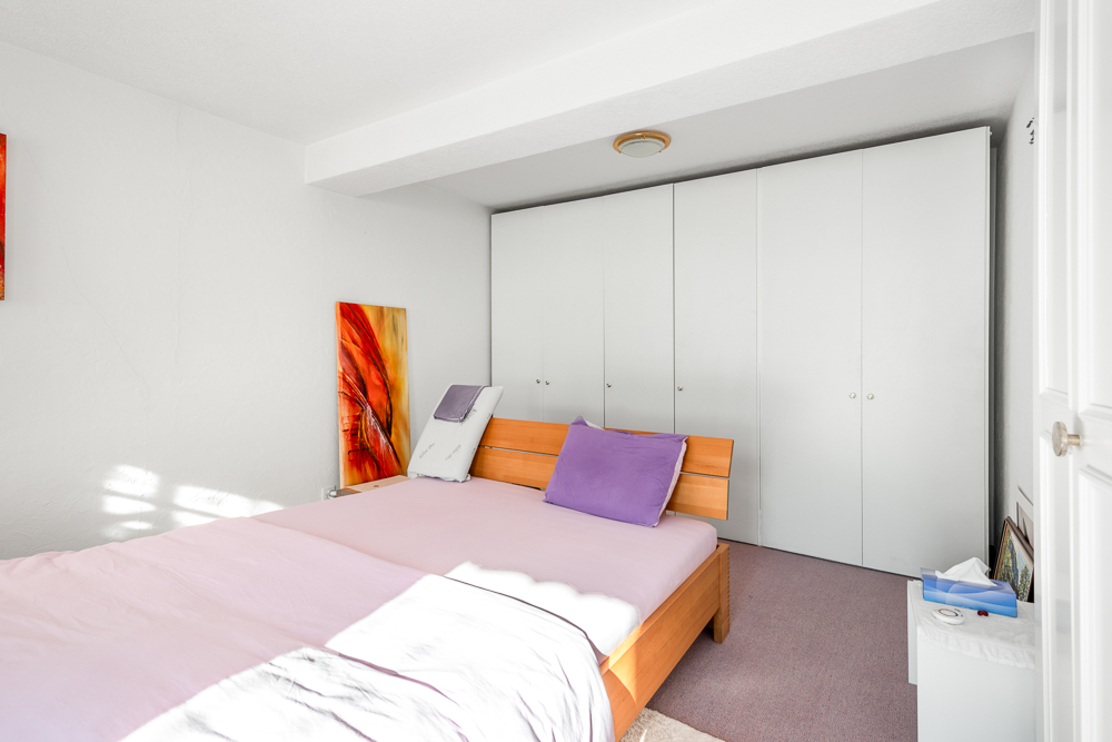 Helles Schlafzimmer mit Doppelbett und Einbauschrank