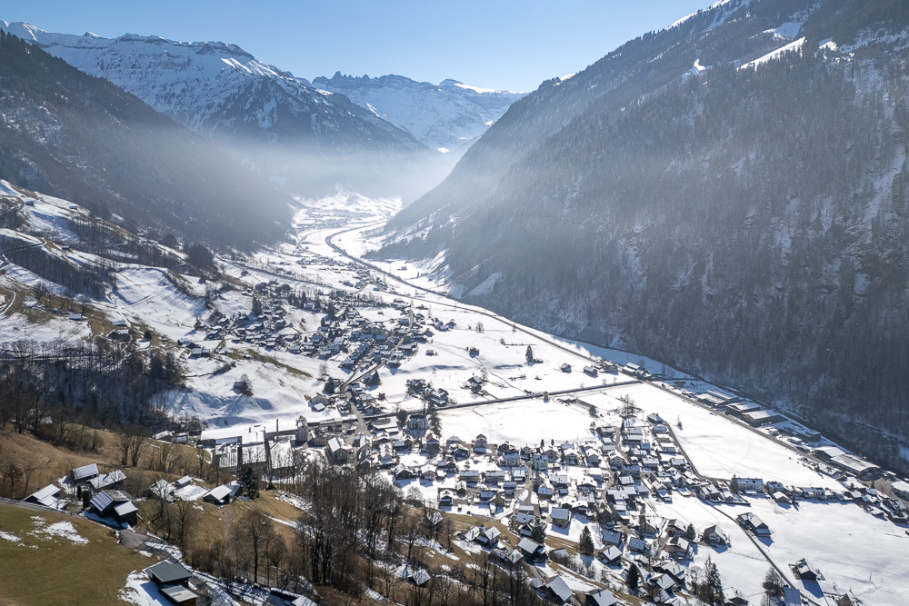 Schneebedeckte Alpentäler mit Dorf im Tal
