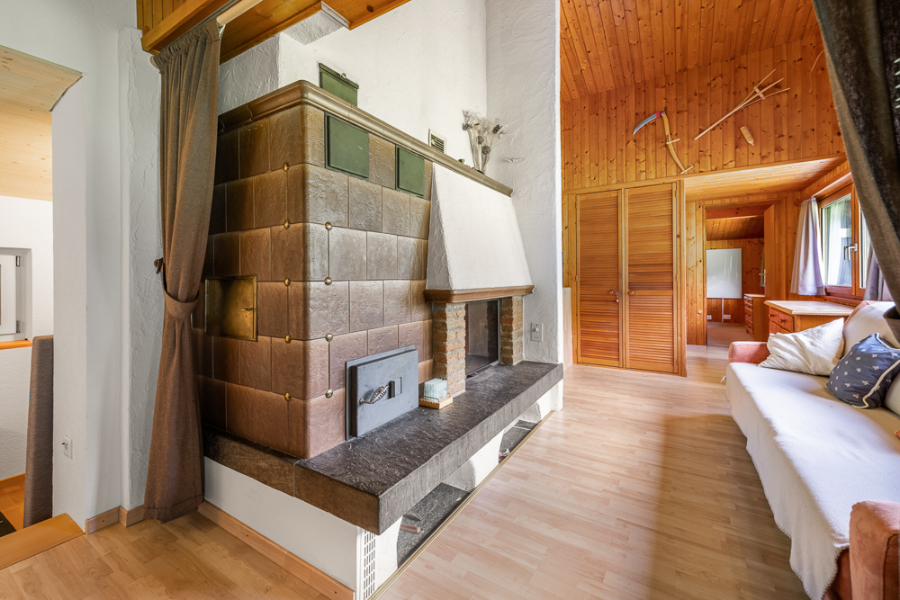 Wohnraum mit Holzverkleidung und Kachelofen