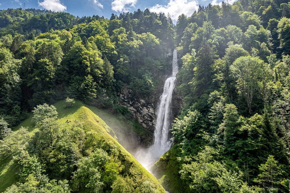 Waldtal mit hohem Wasserfall