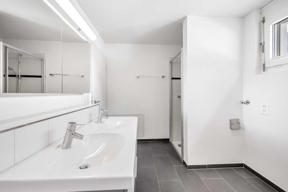 Modernes Badezimmer mit Doppelwaschbecken und Dusche