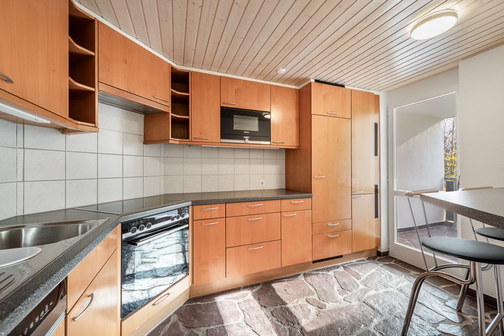 Küche mit Holzfronten und Steinboden
