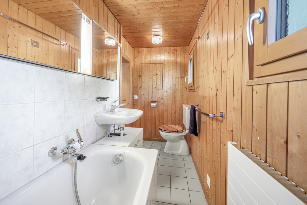 Holzvertäuschtes Badezimmer mit Badewanne und WC