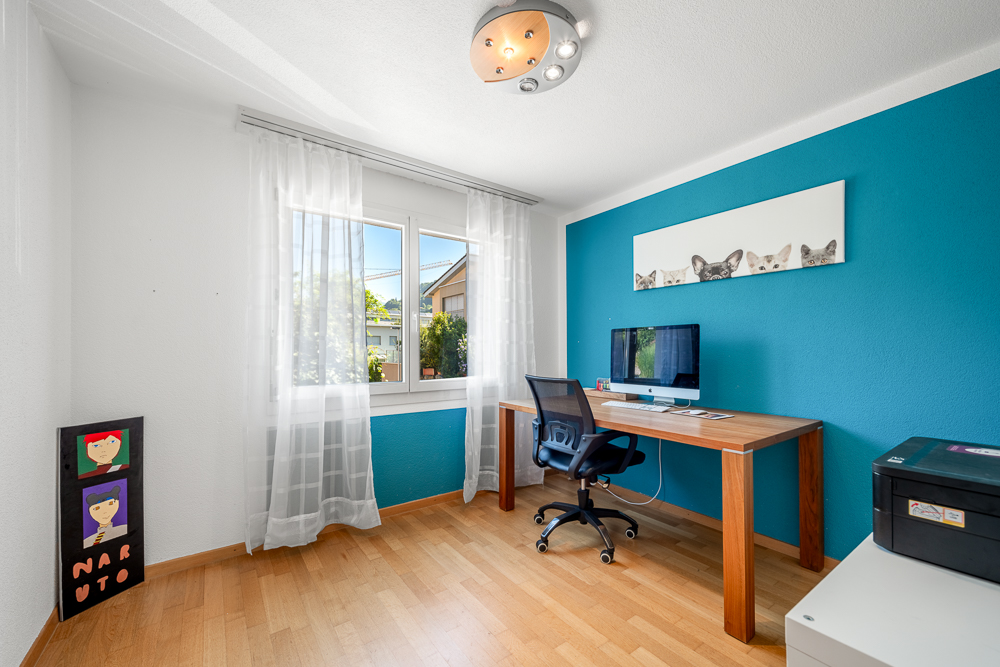 Helles Arbeitszimmer mit blau akzentuierter Wand