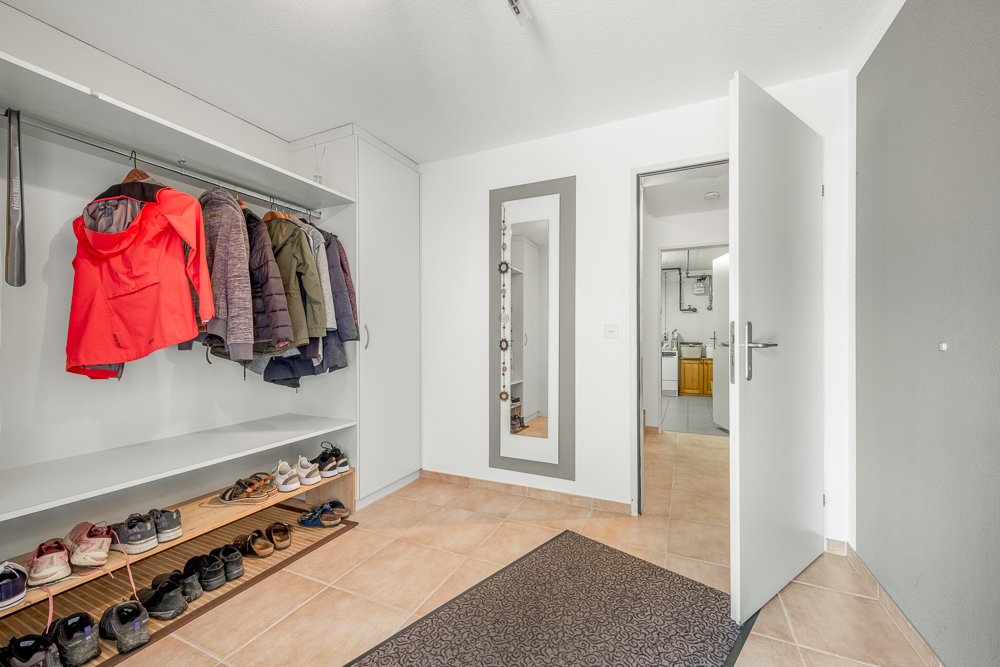 Flur mit Garderobe und offen stehender Tür