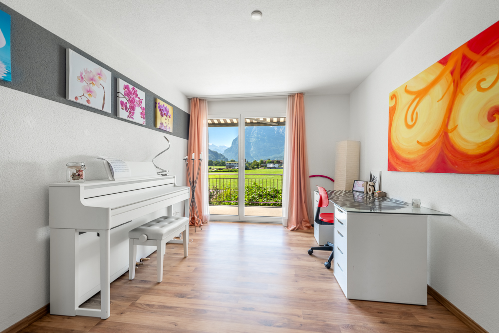 Helles Zimmer mit Klavier und Bergblick