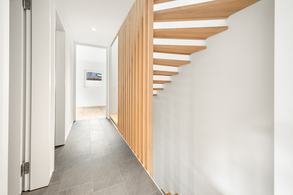 Moderner Flur mit Holztreppe