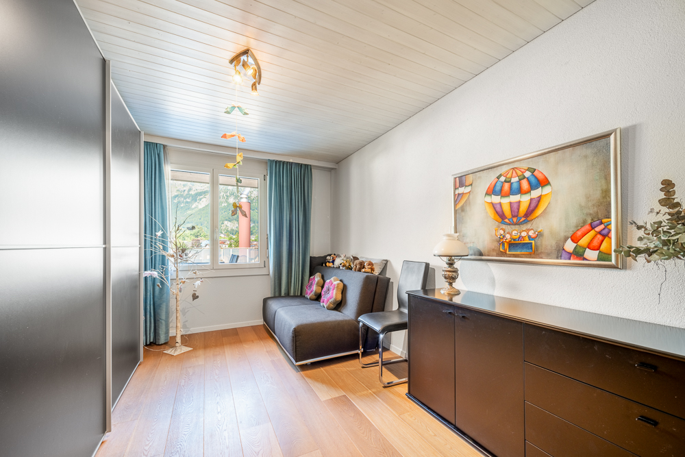 Helles, schmales Wohnzimmer mit Fensterfront und Stauraum