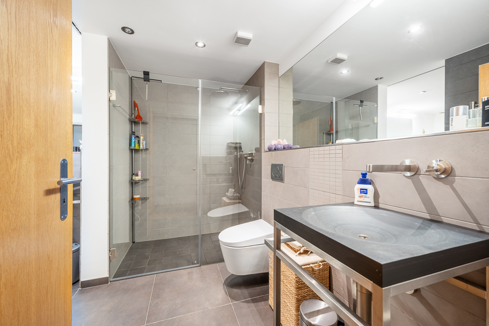 Modernes Badezimmer mit Glasdusche und Waschtisch