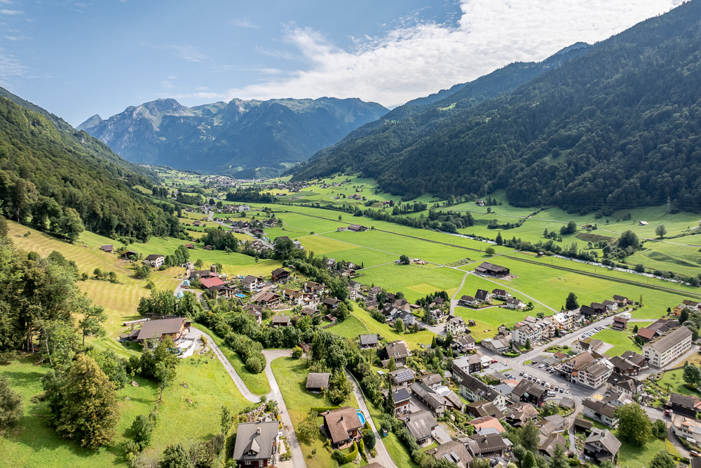 Bergtal mit Siedlung und Wiesen
