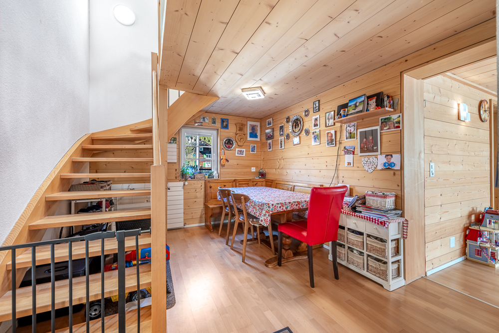 Gemütlicher Essbereich mit Holzverkleidung und Treppe
