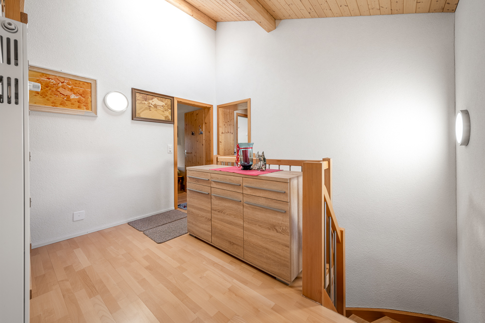 Heller Flur mit Holzdecke und Sideboard