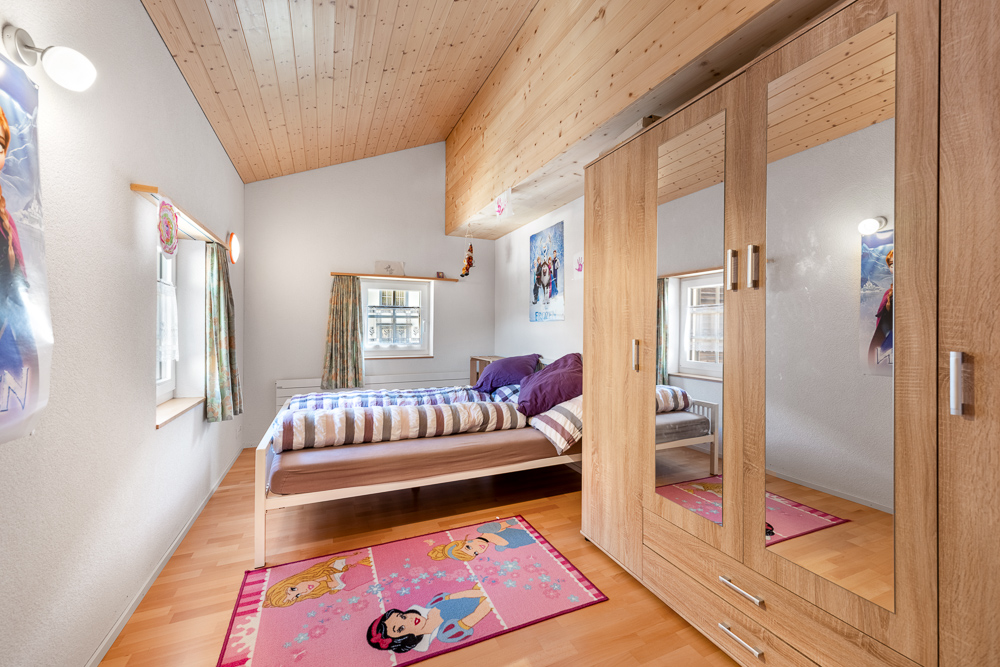 Kinderzimmer mit Holzdecke und Kleiderschrank
