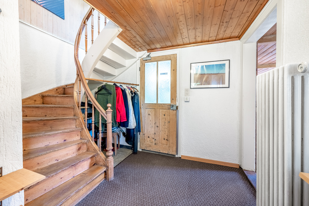 Treppenhaus mit Holztreppe und Garderobe