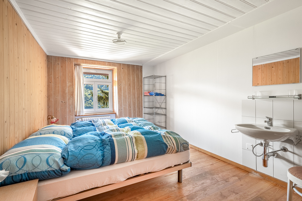 Helles Schlafzimmer mit Holzverkleidung und Waschplatz