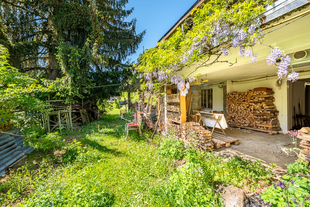 Garten mit Holzlager und überdachter Terrasse