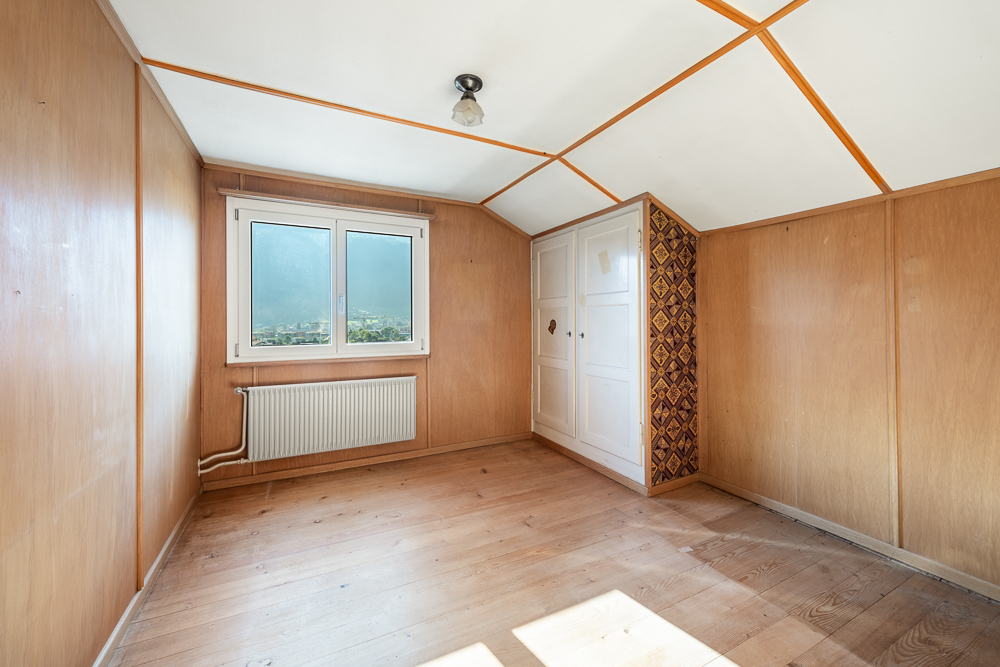 Leerer Holzraum mit Fenster und Einbauschrank