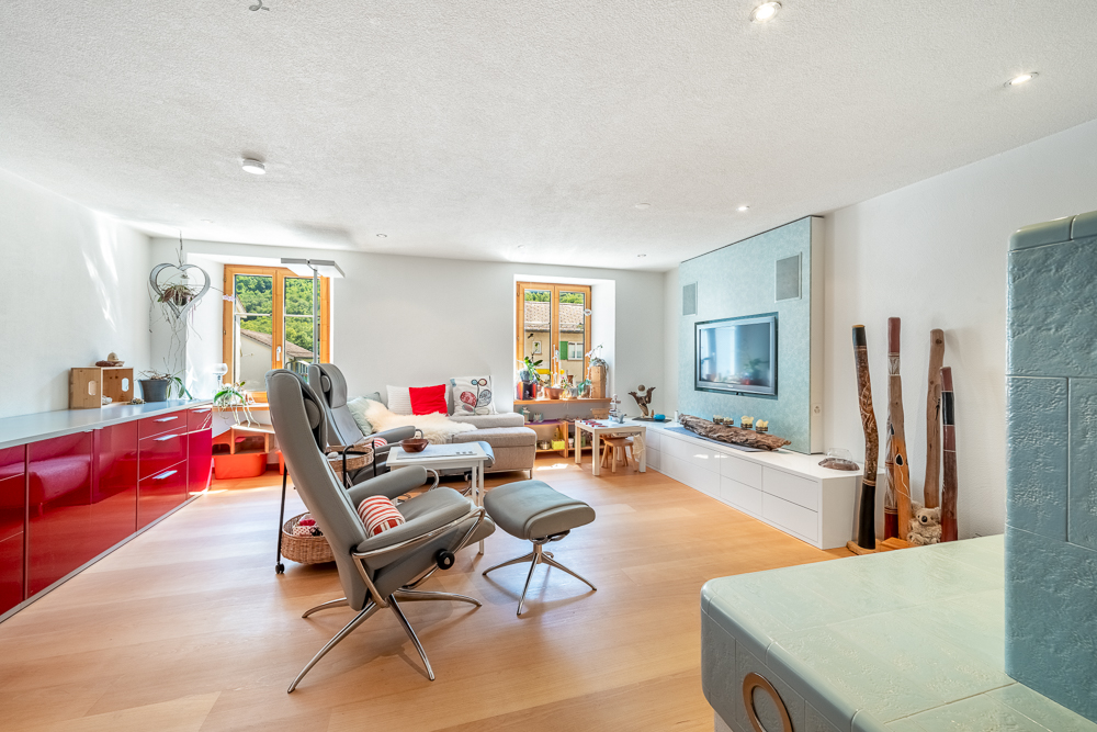 Heller Wohnraum mit Sitzbereich und TV-Wand