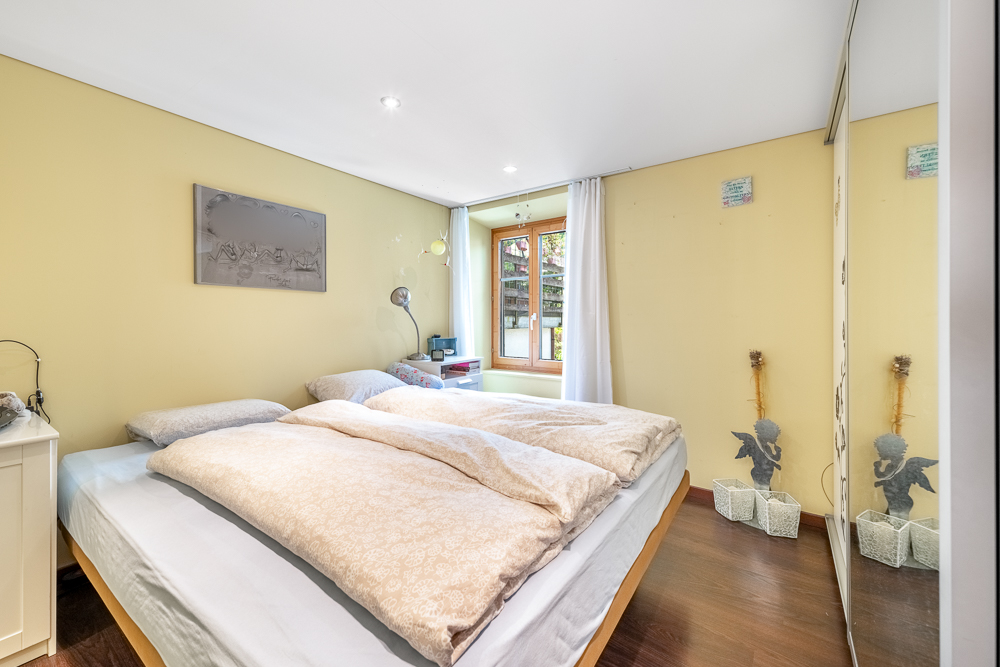 Helles Schlafzimmer mit Doppelbett und Fenster