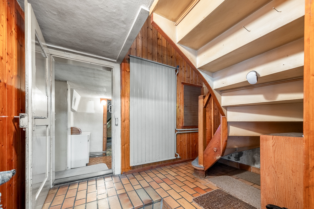 Treppenhaus mit Holzverkleidung und Fliesenboden