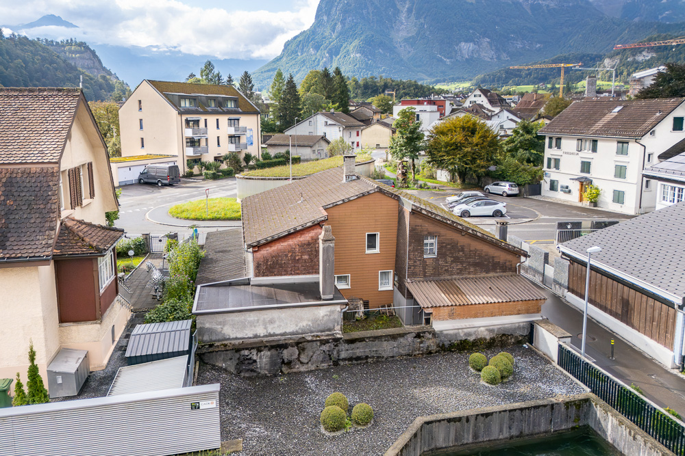 Blick über ein alpines Wohngebiet mit Bergen im Hintergrund