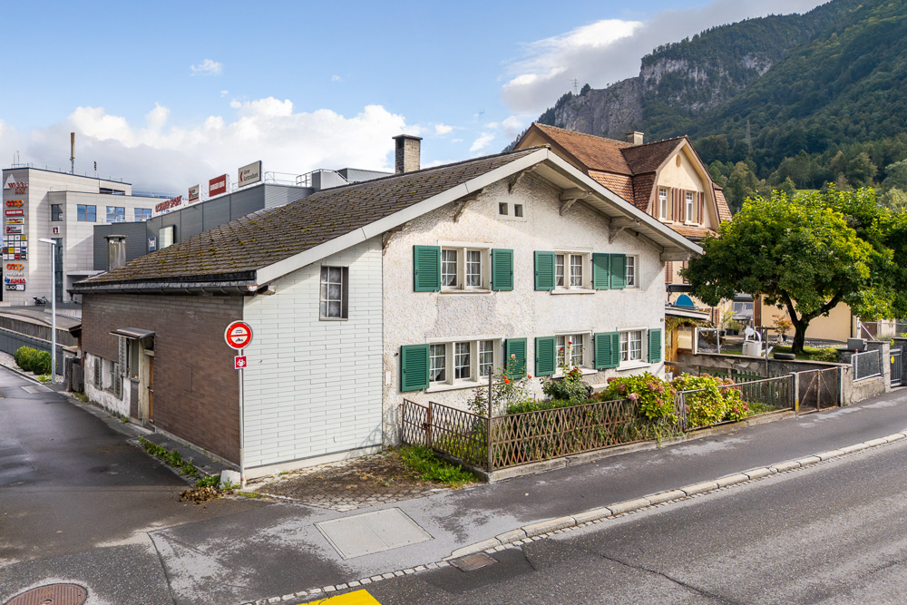 Straßenansicht eines Wohnhauses mit Bergkulisse