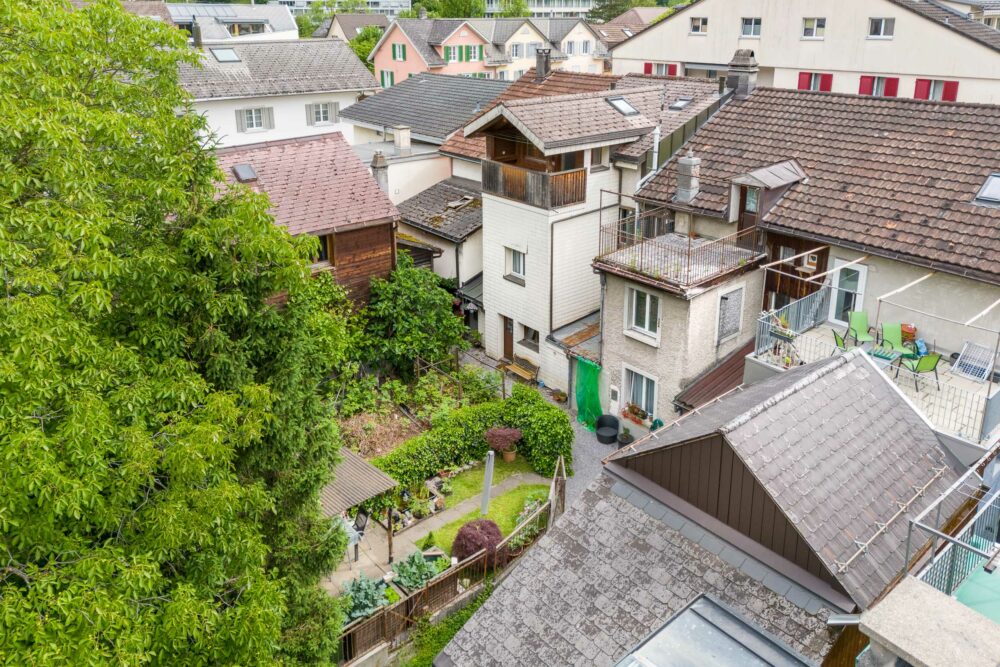 Blick über dicht bebautes Wohnquartier mit Balkonen und Gärten