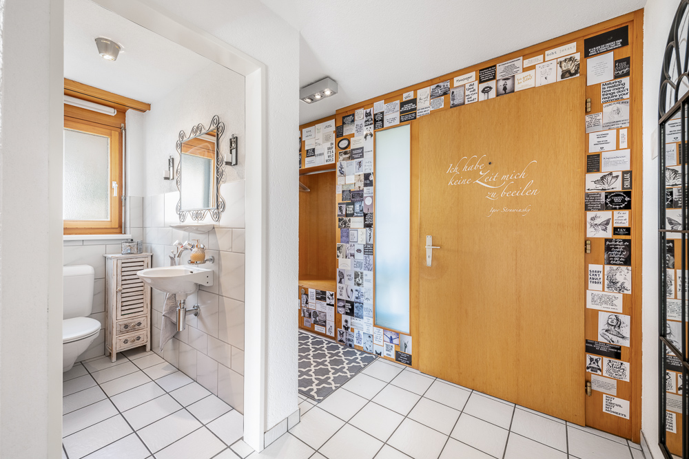 Badezimmerflur mit WC und dekorierter Tür