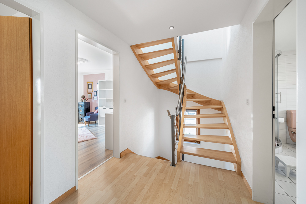Heller Flur mit Holztreppe