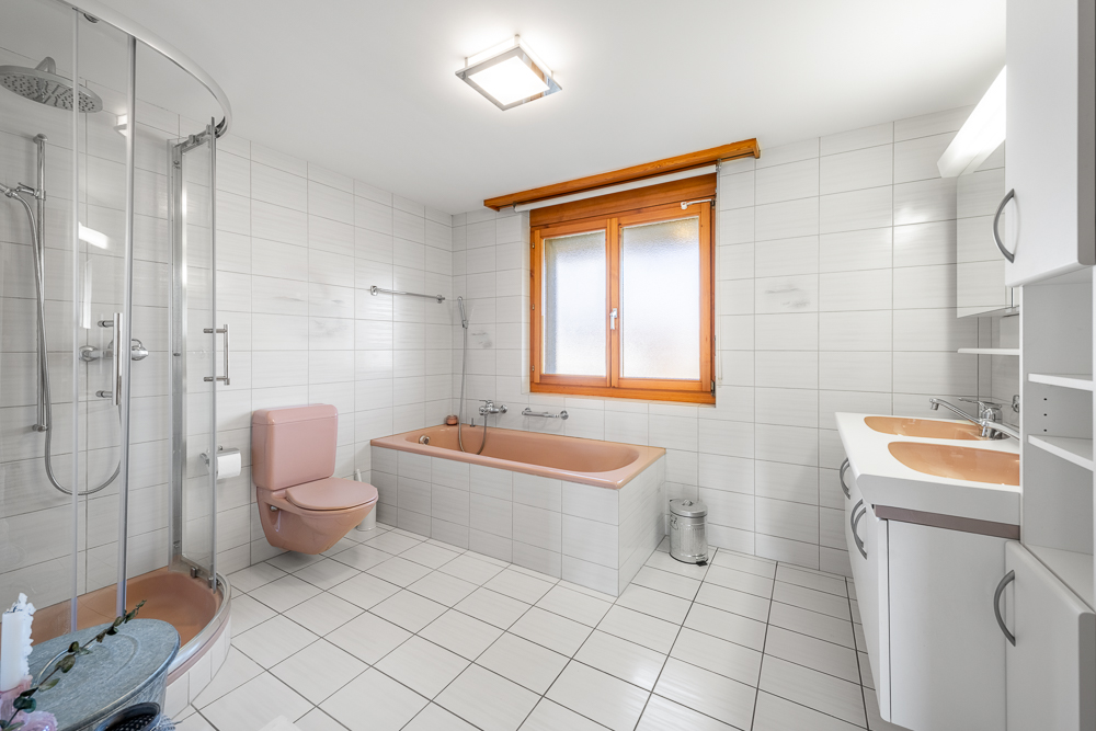 Badezimmer mit Dusche, Wanne und Doppelwaschtisch