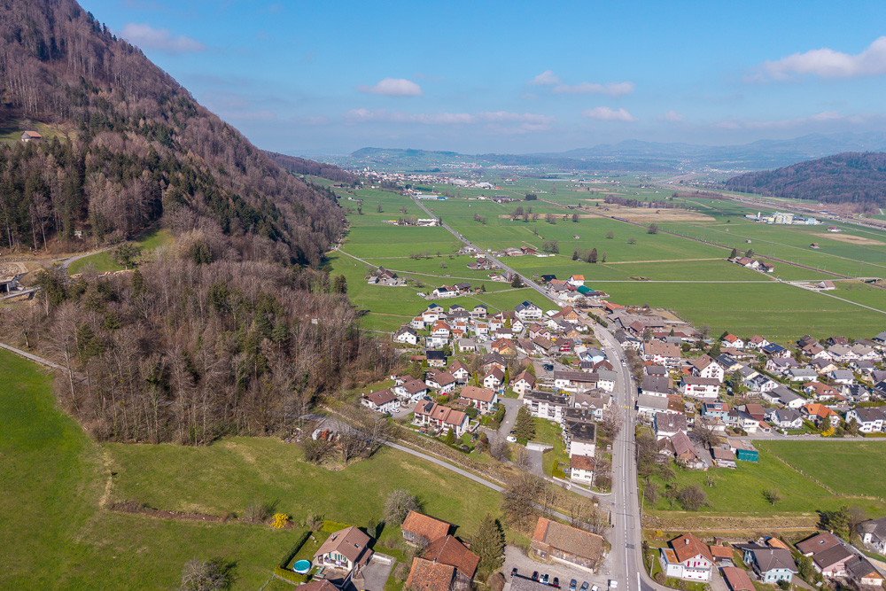 Luftaufnahme eines Tals mit Siedlung und Feldern