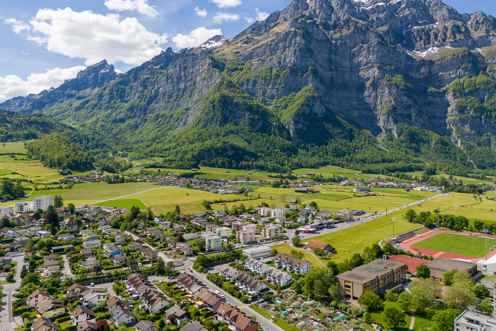 Alpenlandschaft mit Tal, Ort und Bergen