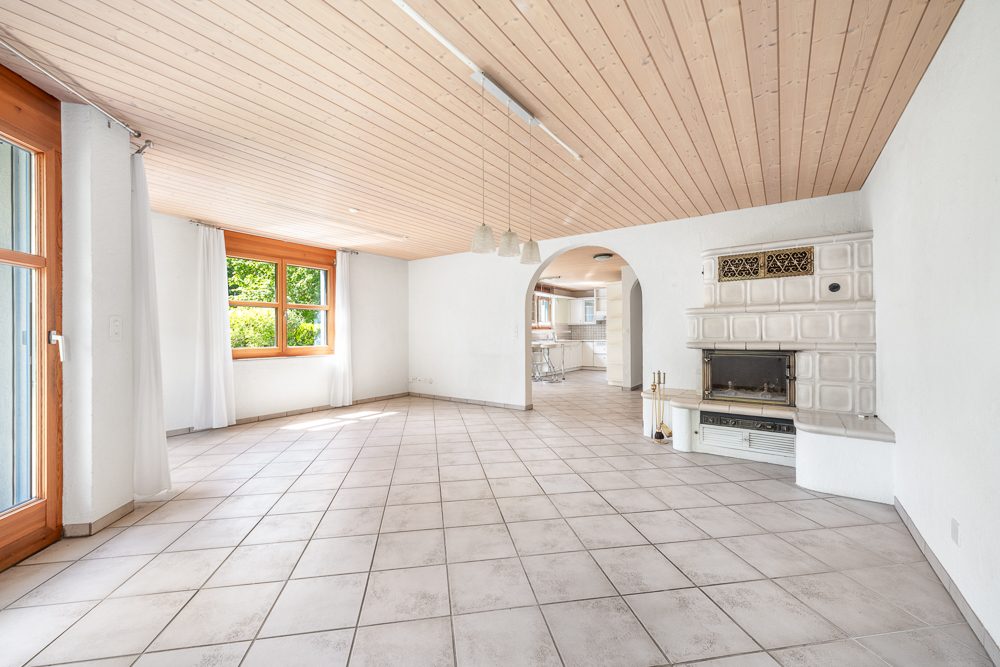 Heller Wohnraum mit Kamin und Rundbogenöffnung
