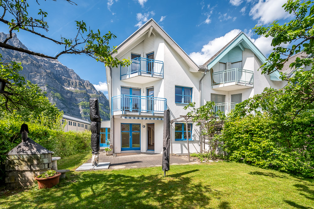 Mehrfamilienhaus mit Gärten und Bergkulisse